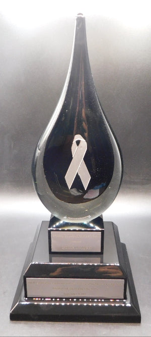Trophy with a white ribbon symbol on a reflective surface