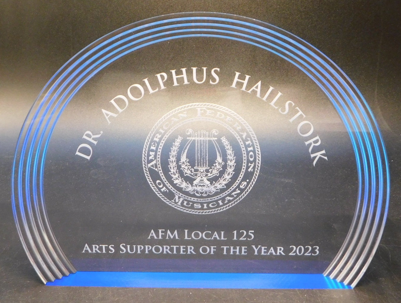 Acrylic award with blue lighting on a dark surface
