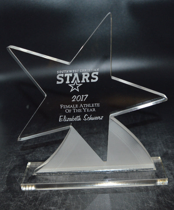 Star-shaped award with engraved text on a dark background