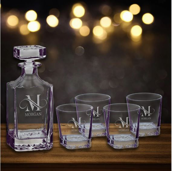 Crystal decanter and glasses with 'Morgan' branding on a wooden surface with blurred lights in the background in Norfolk, VA