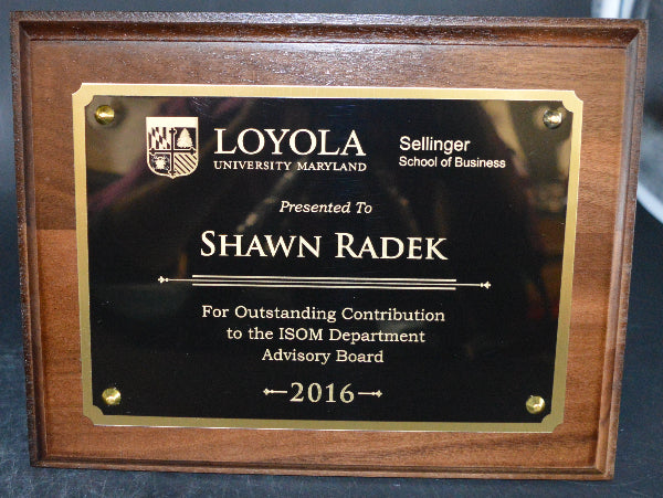 Plaque awarded to Shawn Radek by Loyola University Maryland on a dark surface