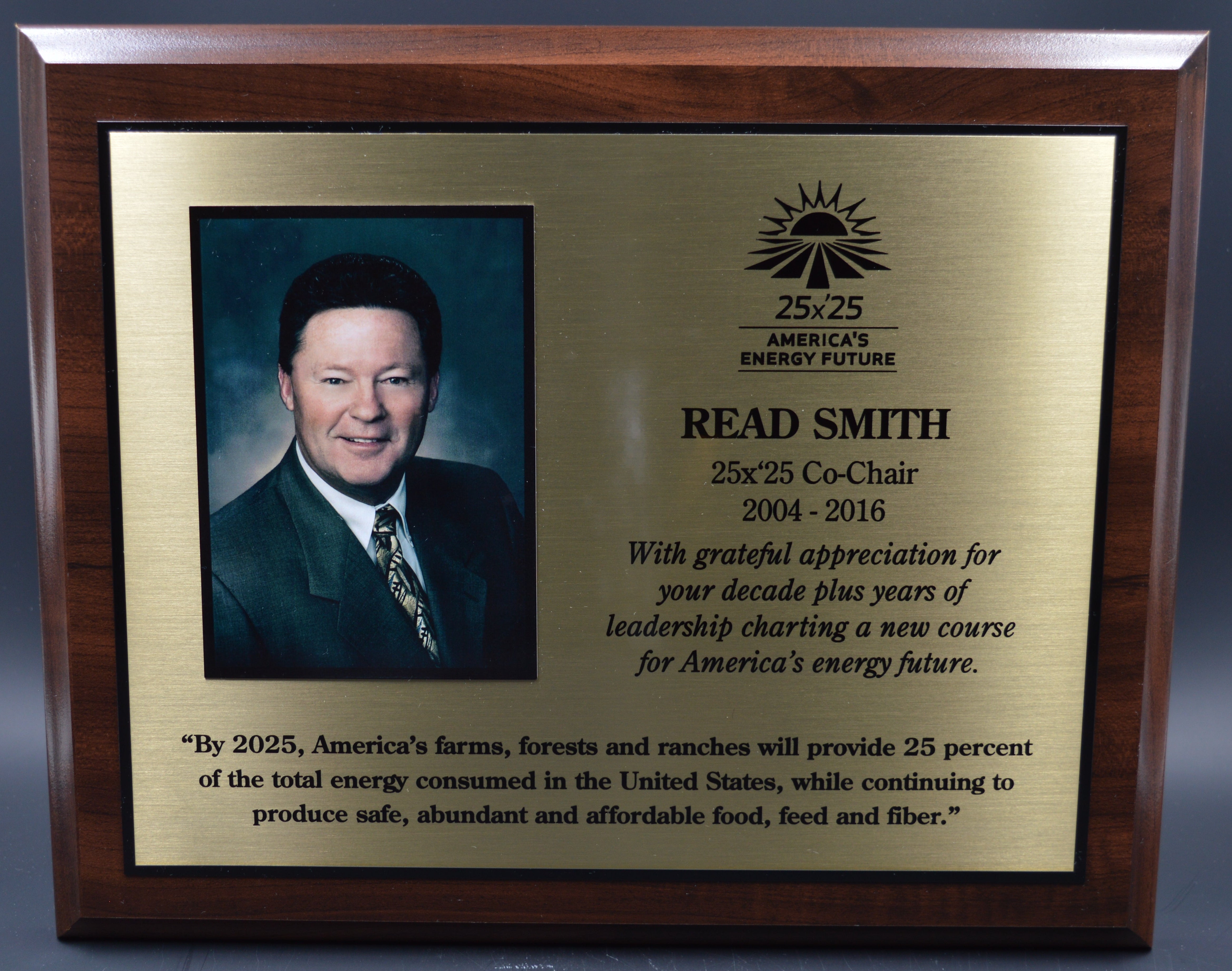 Plaque with a portrait of a man and engraved text on a dark background