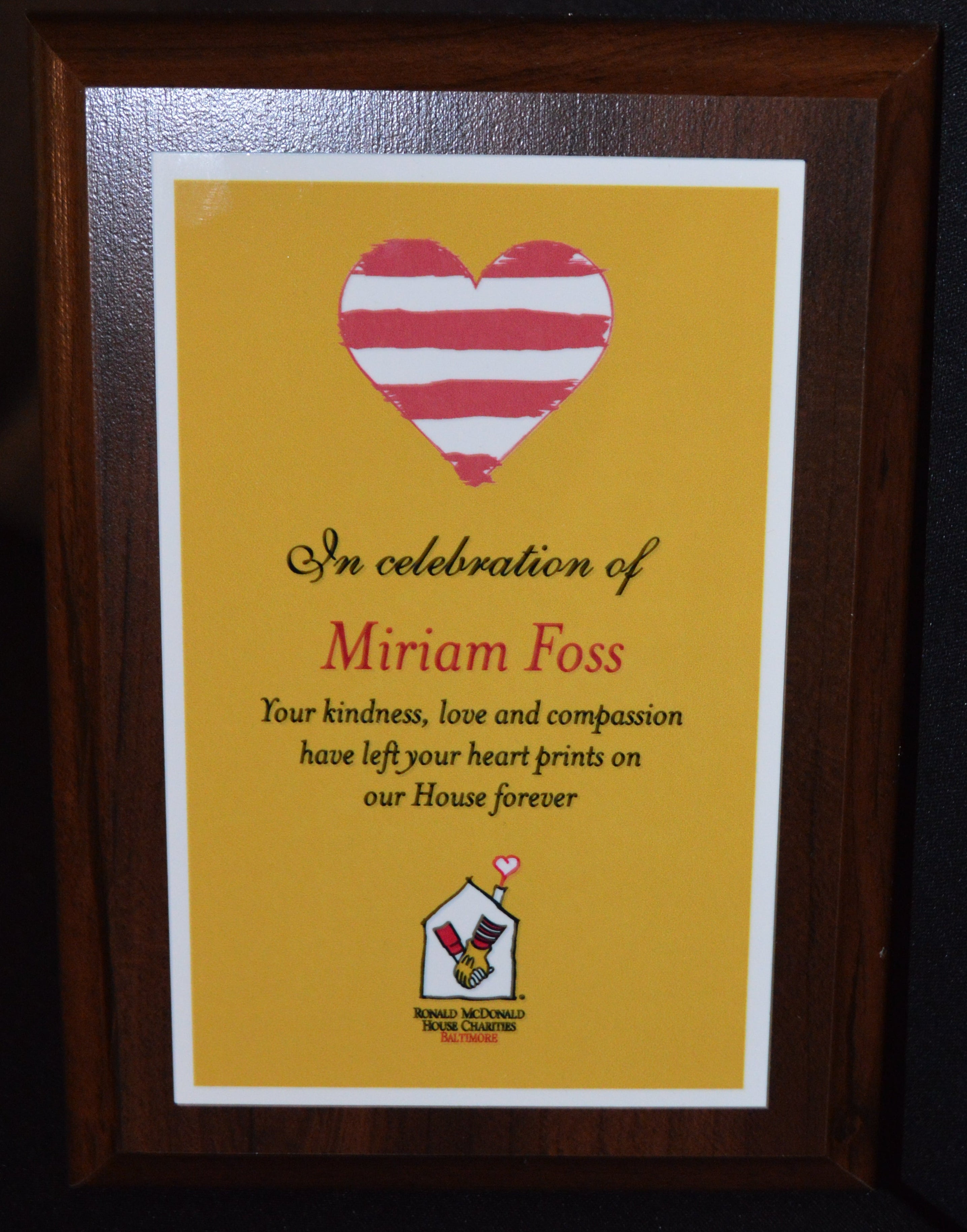 Framed memorial plaque with a heart design and text on a dark background