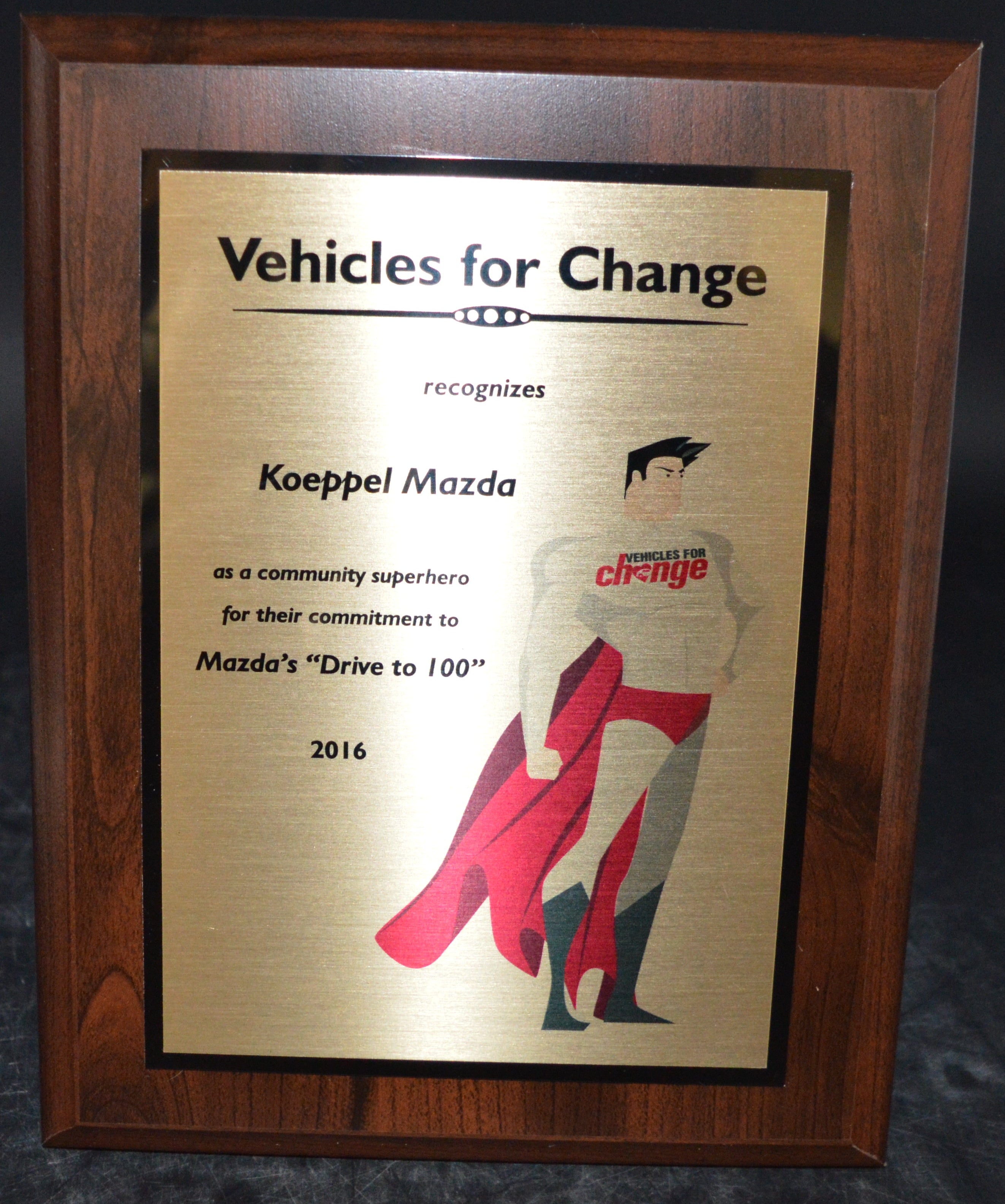 Wooden framed award plaque for 'Koeppel Mazda' recognizing 'Vehicles for Change'.