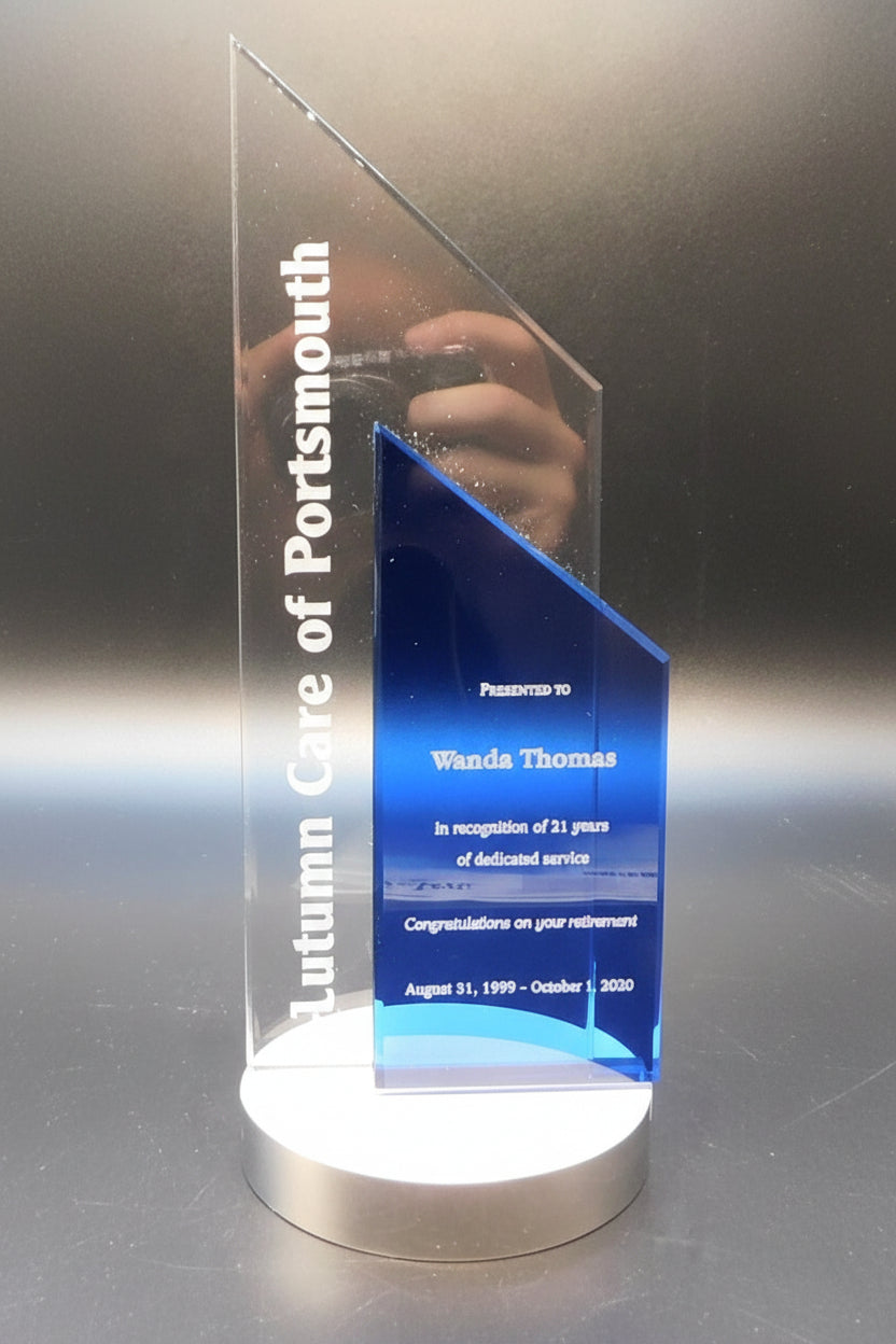 Acrylic award with engraved text on a reflective surface