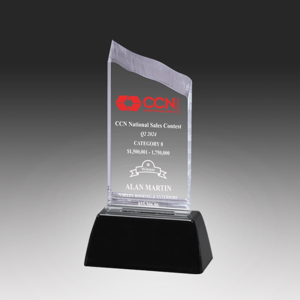 Clear acrylic award with engraved text on a black base against a gray background