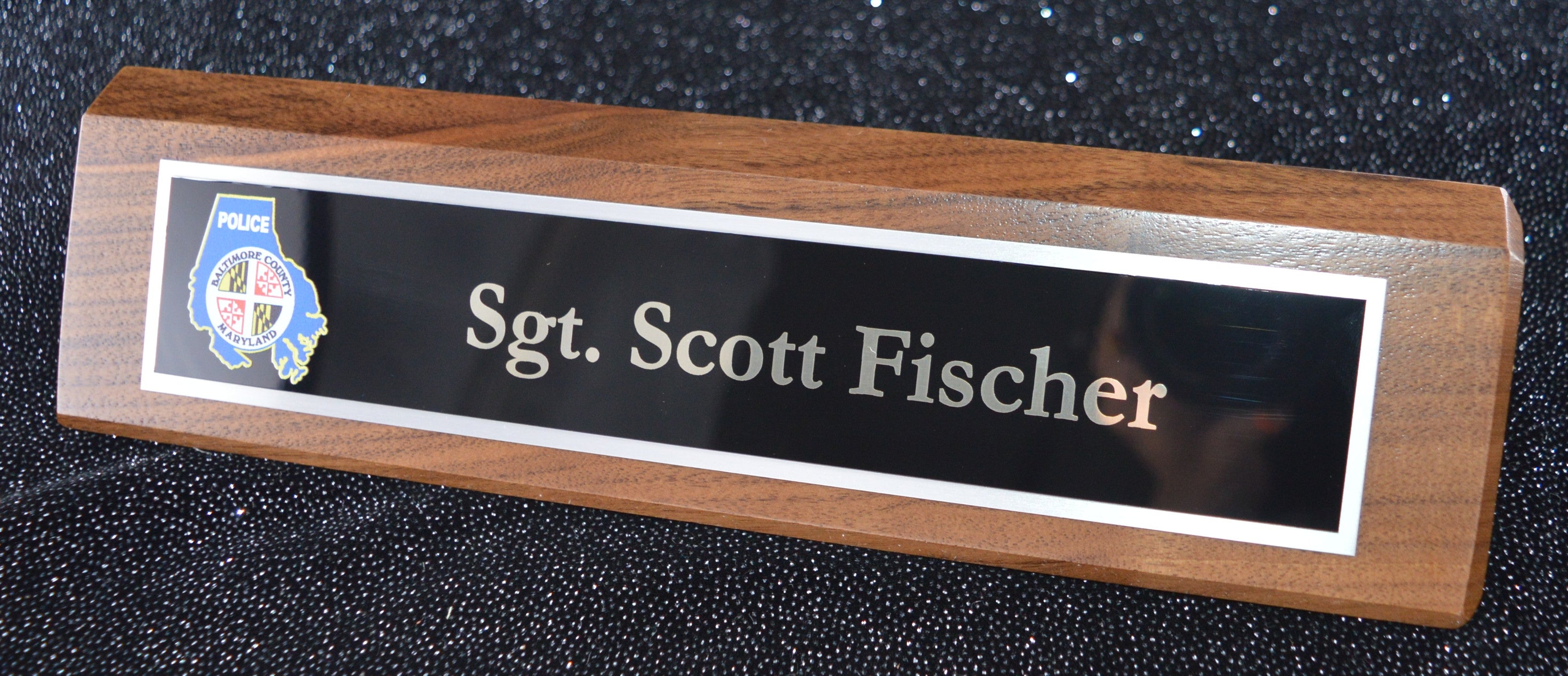 Nameplate with 'Sgt. Scott Fischer' on a dark background