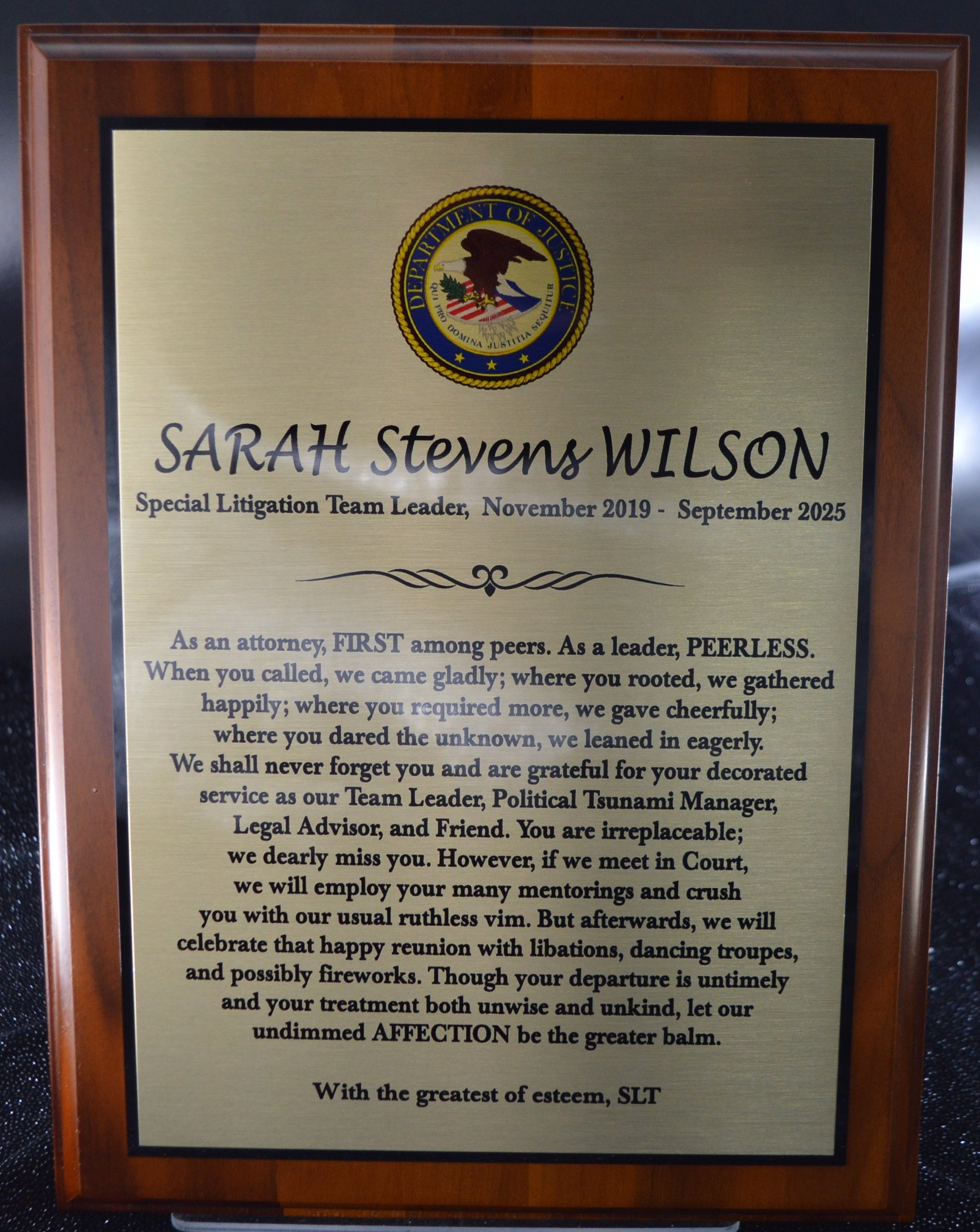 Framed certificate or plaque with text and a logo on a dark background