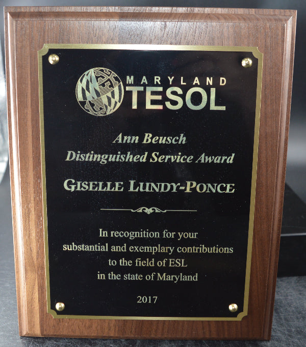 Wooden plaque with TESOL logo and text on a reflective surface