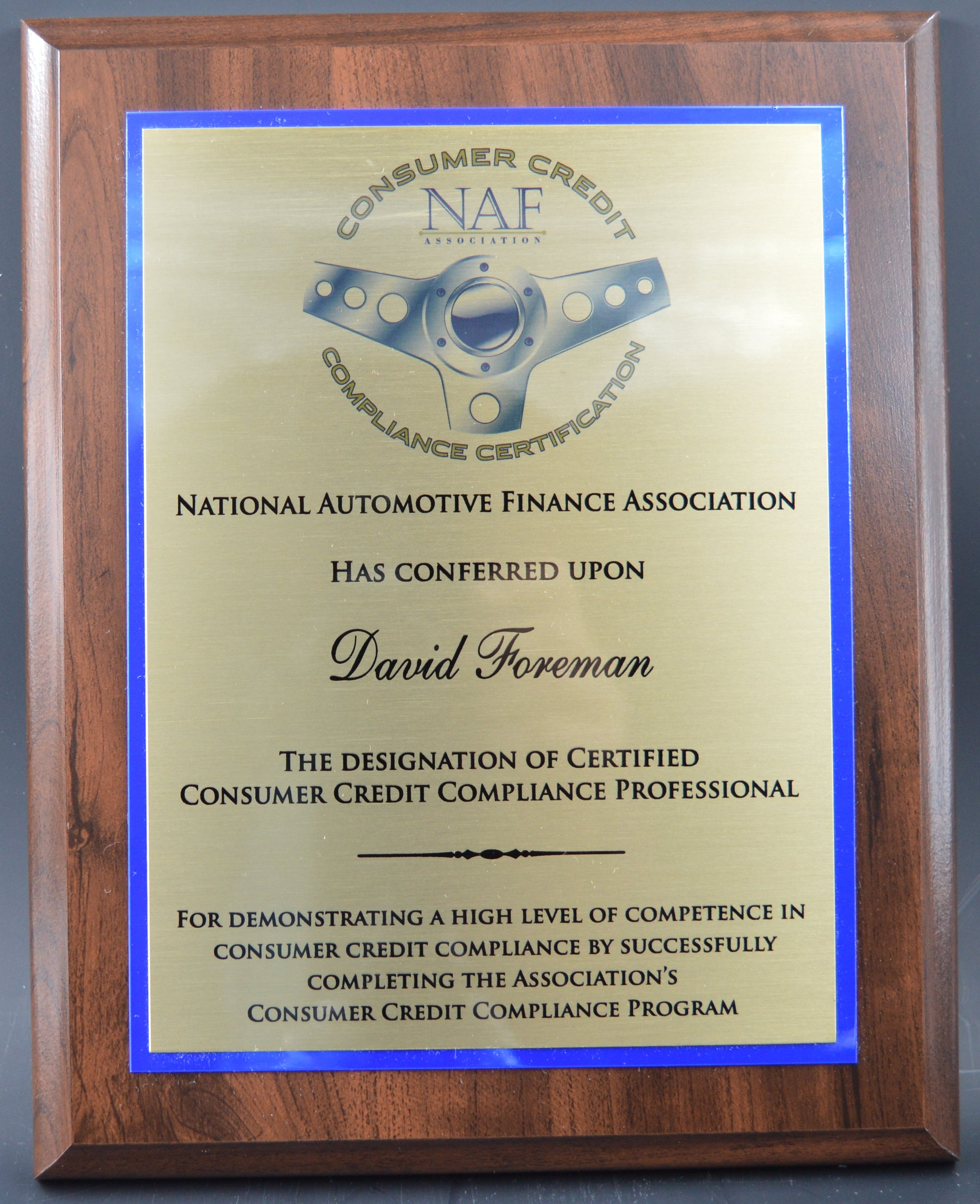 Plaque with National Automotive Finance Association certification on a gray background