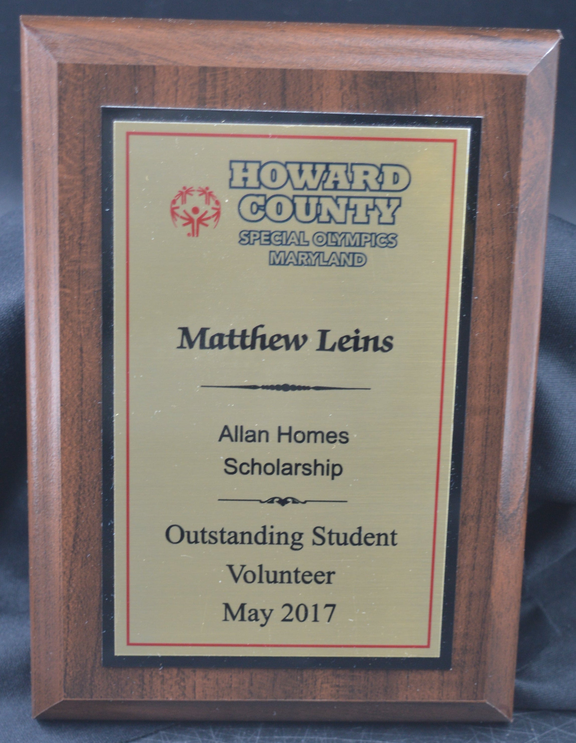 Wooden plaque with a certificate on a blue fabric background