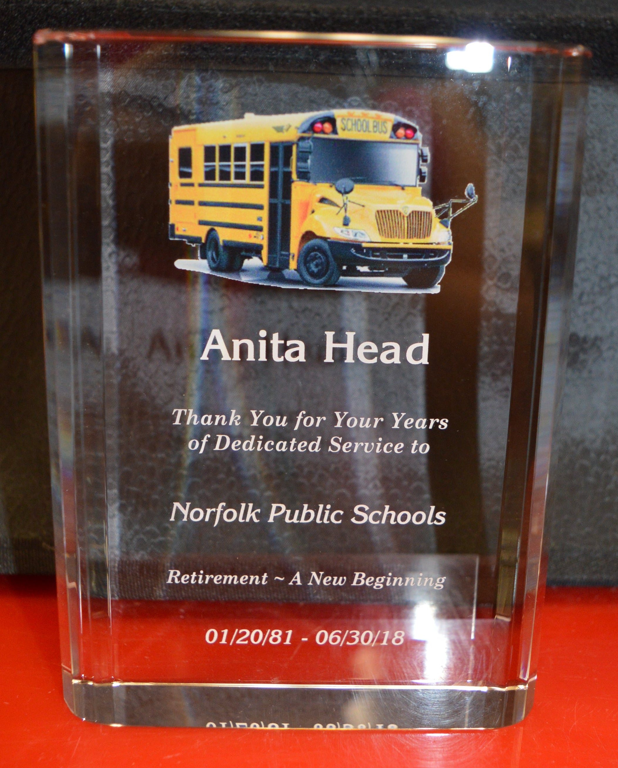 CRYSTAL plaque with a school bus illustration and text on a reflective surface