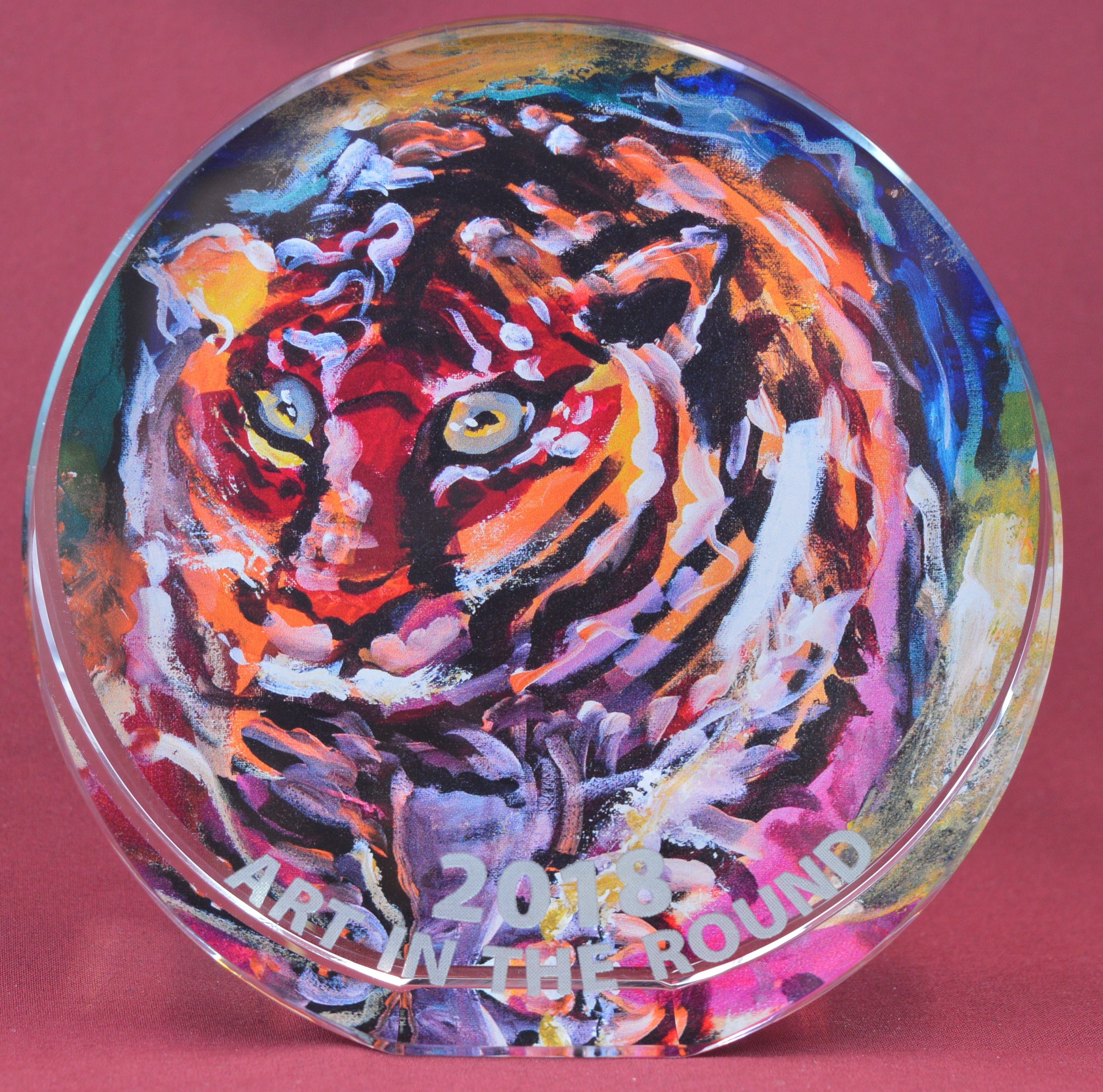 Colorful tiger artwork on a round glass plate with 'Art on the Round' branding.