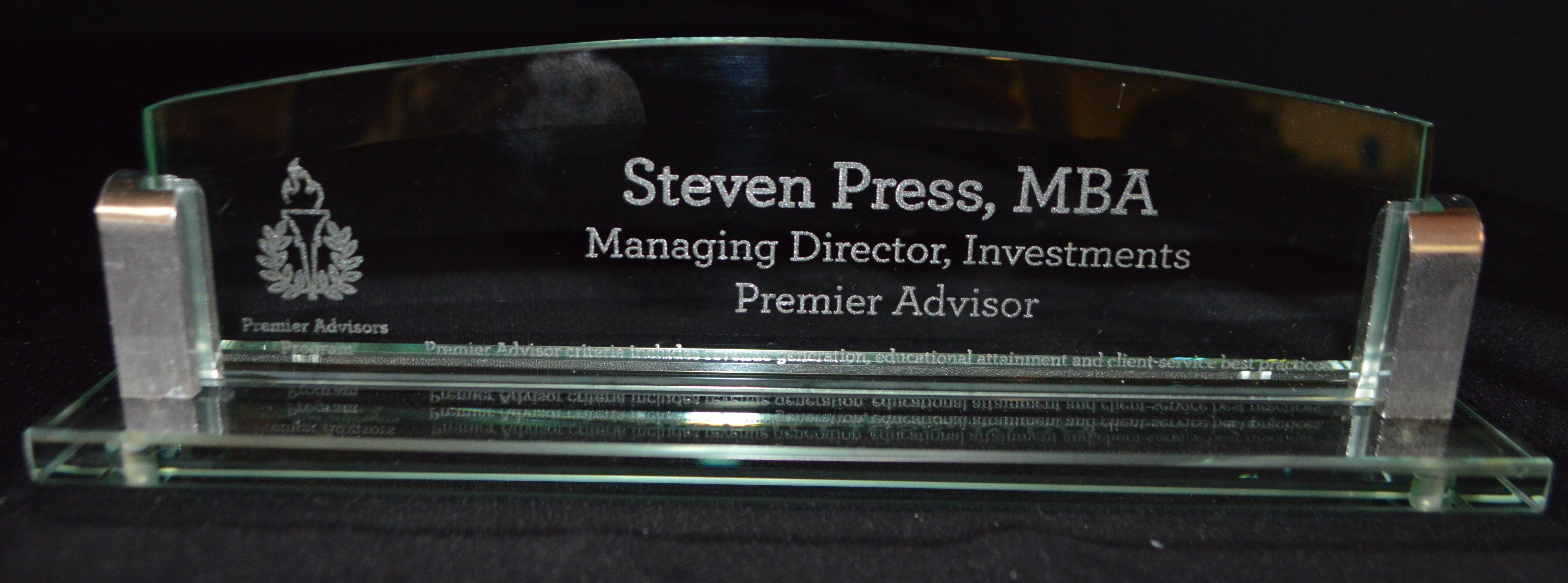 Glass nameplate with engraved text on a black background