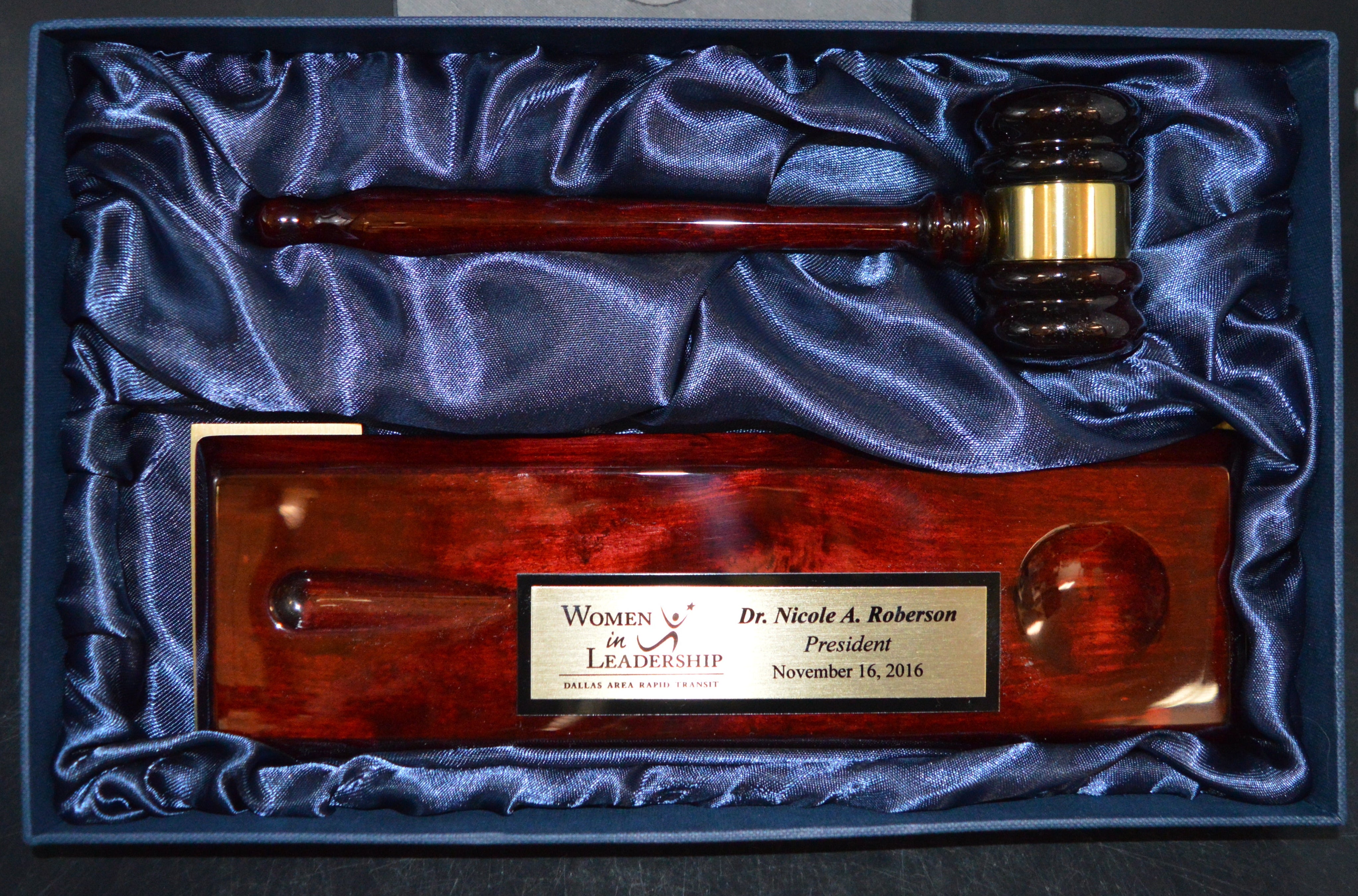 Wooden gavel and mallet set in a blue box on a black background